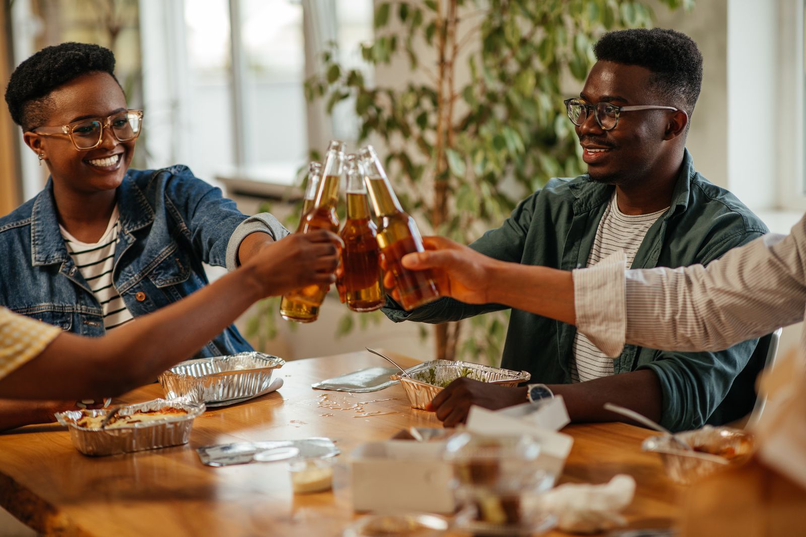Friends toasting with beers around a table